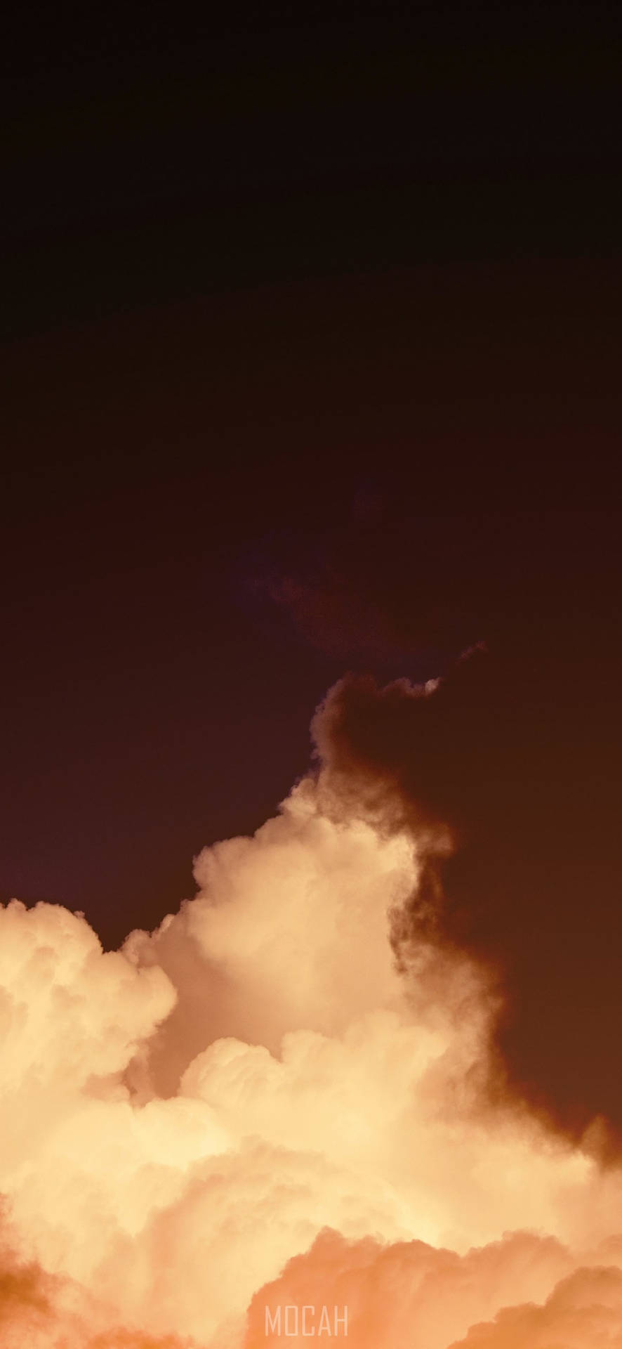  壁紙 — 體積龐大的雲朵在深沉的暮色天空中閃耀著琥珀色和橙色，形成戲劇性的垂直構圖。
