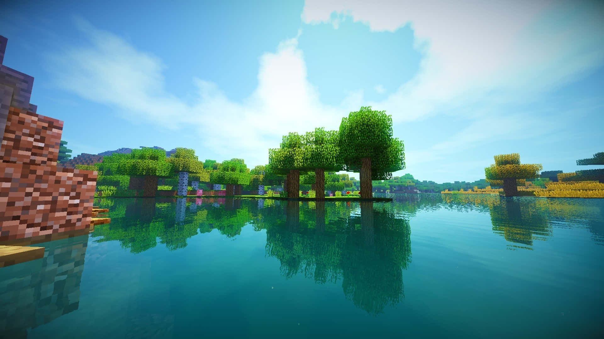 Minecraft 景觀，像素化的樹木和石塊在藍天下平靜的水中倒映。