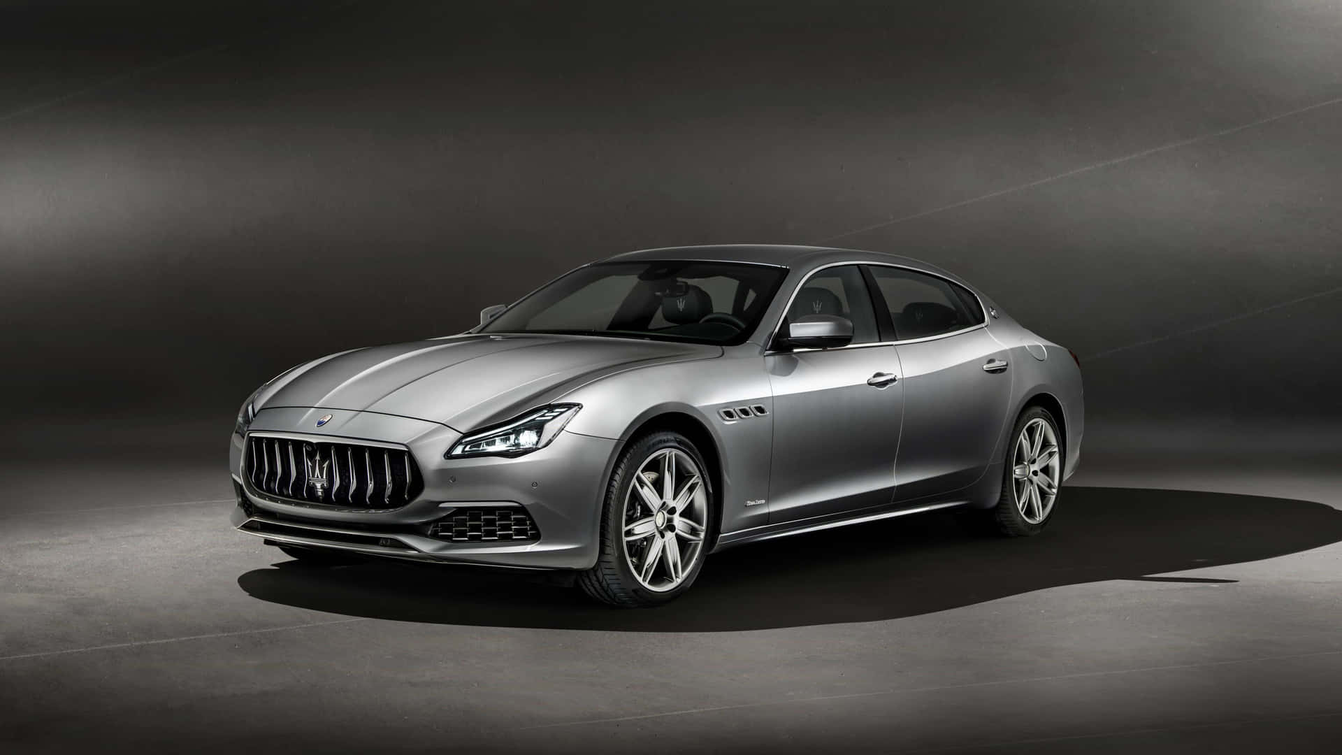 銀色瑪莎拉蒂 Quattroporte 豪華轎車在工作室中，帶有戲劇性燈光。