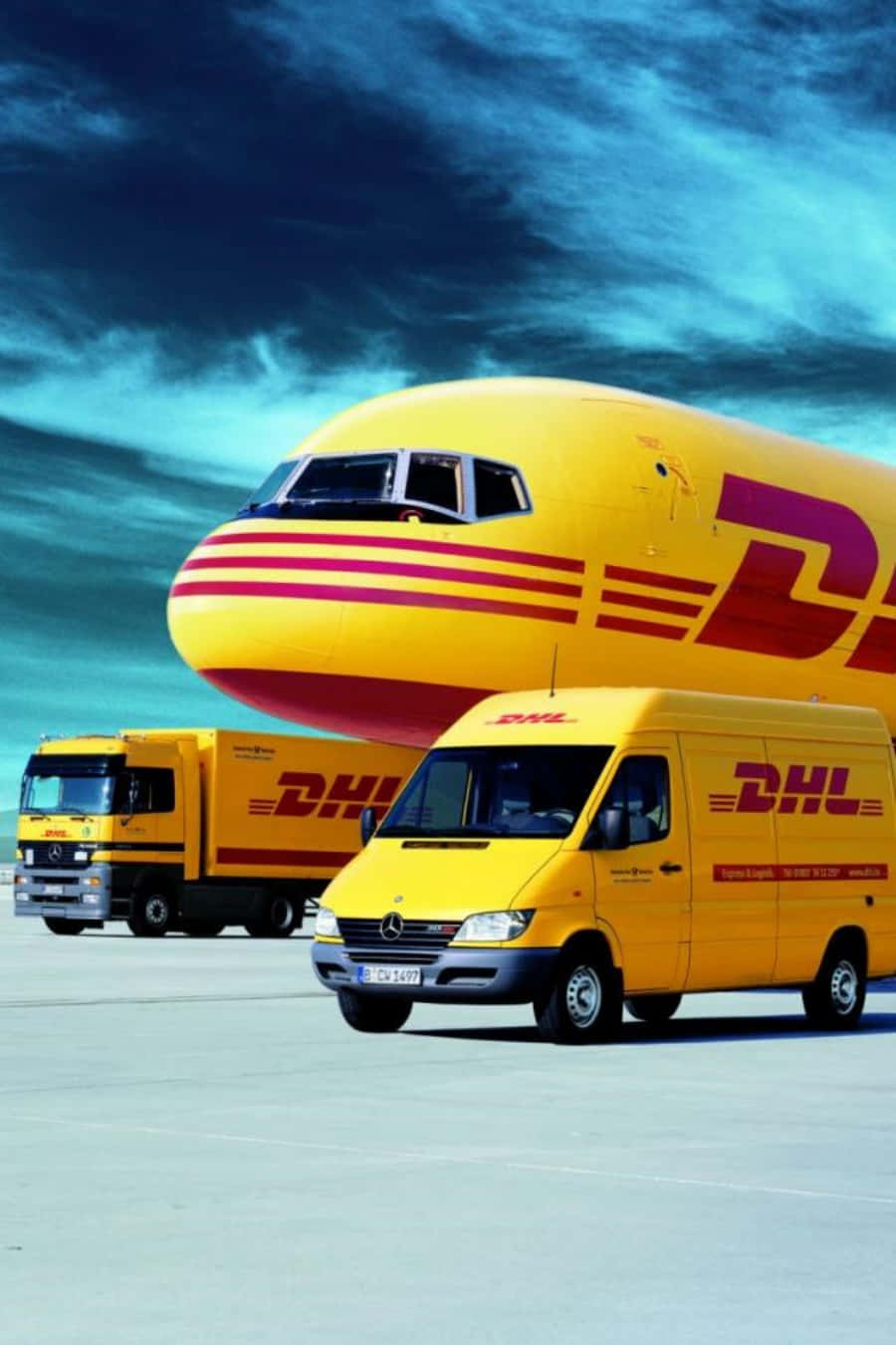暴風雨天空下機場停機坪上的DHL貨機和卡車