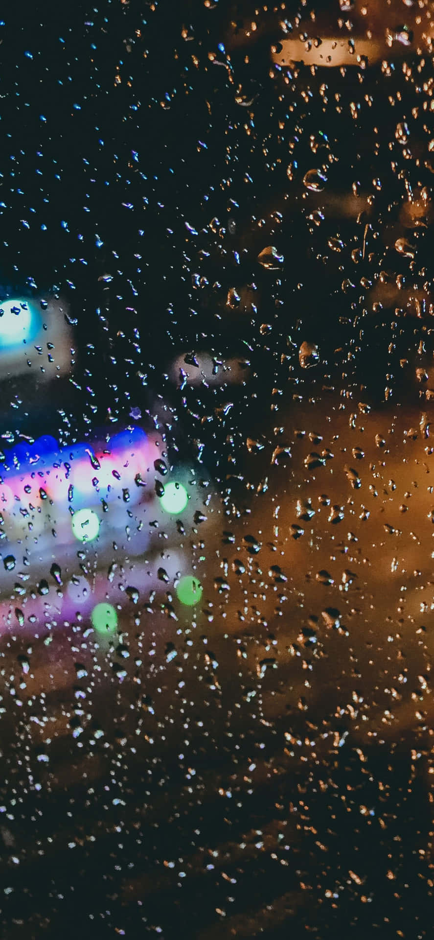 窗戶上的雨滴，夜晚模糊的城市燈光閃爍。