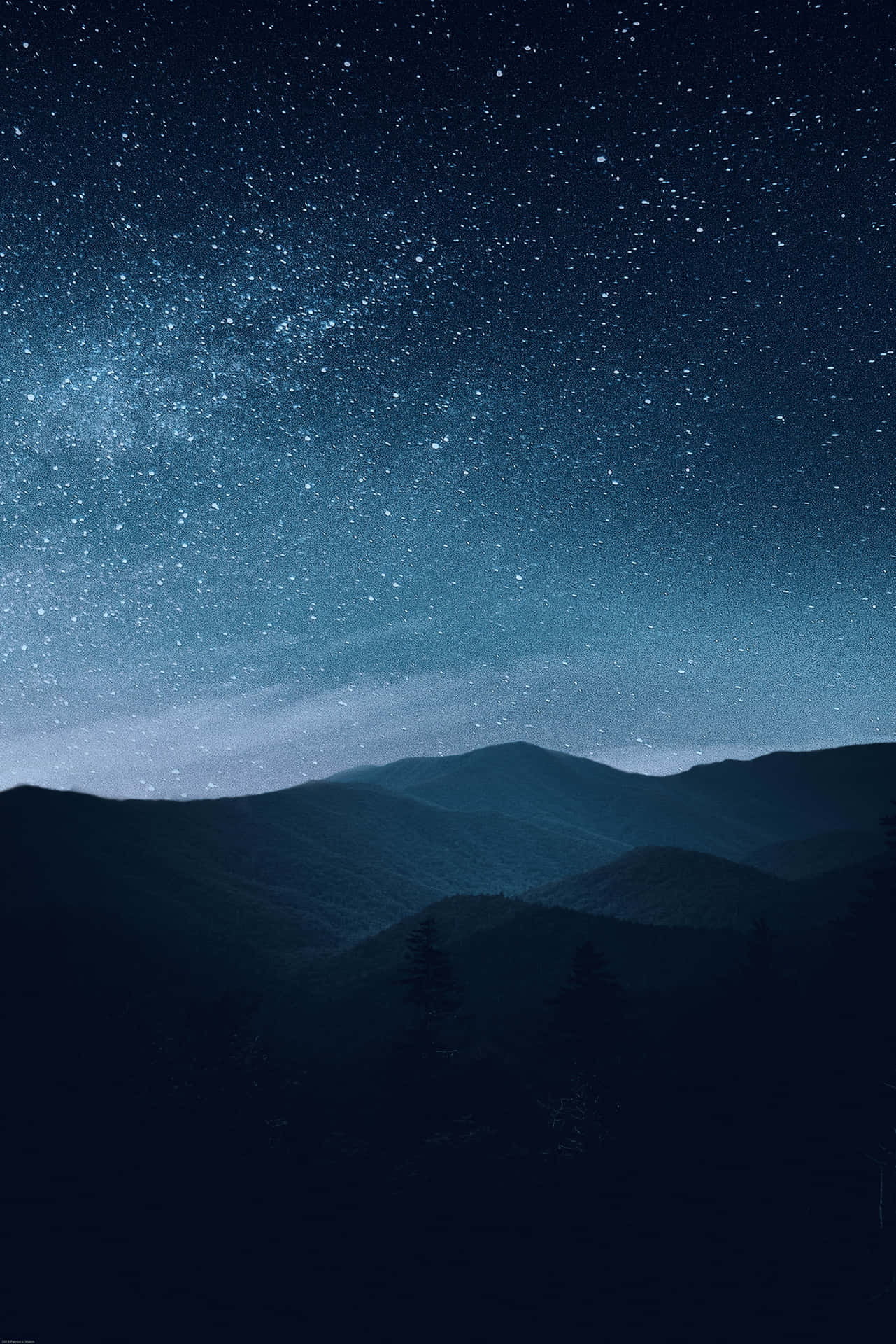 在星空下，剪影般的山脈，銀河可見。