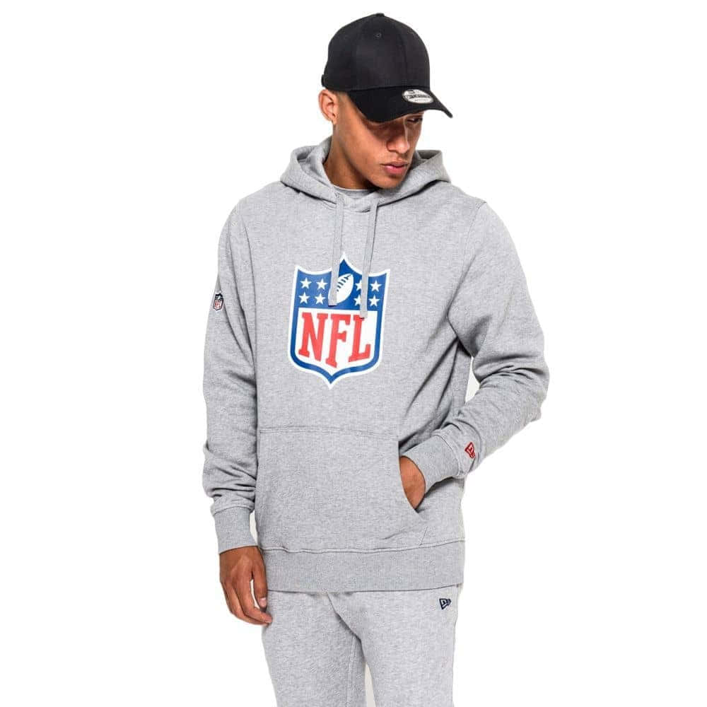 年輕男子穿著NFL品牌灰色連帽衫和運動褲，戴黑色帽子。