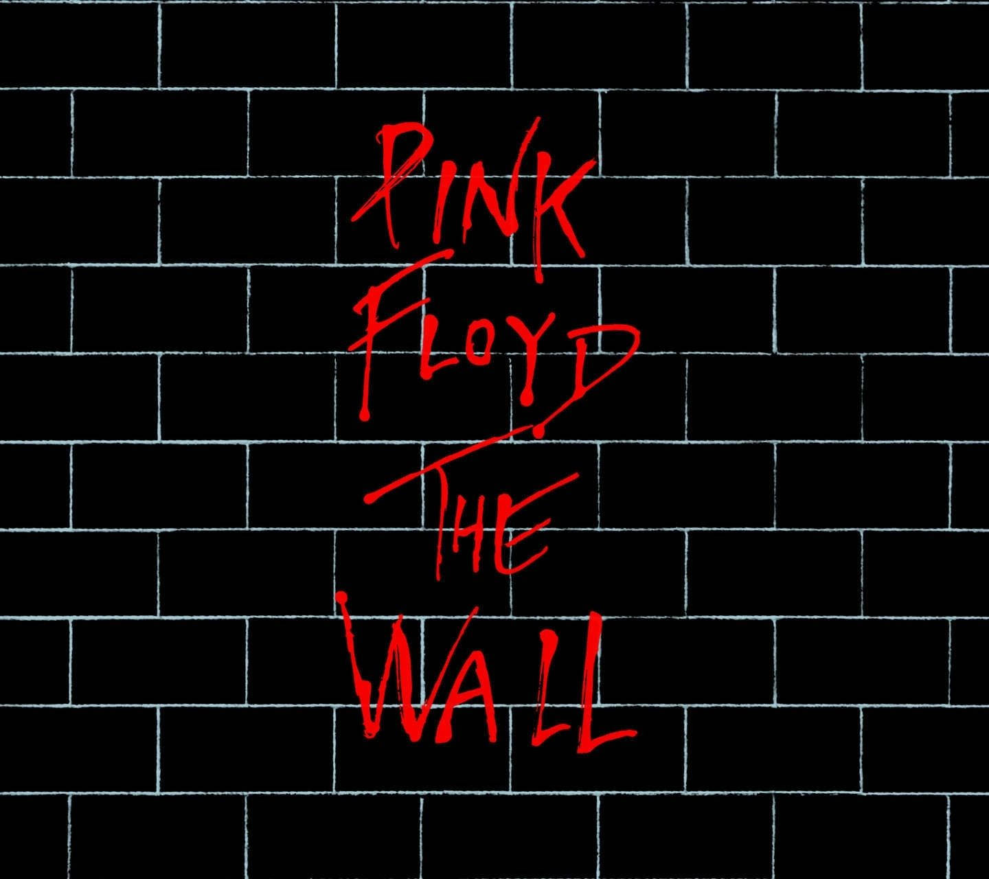 黑色磚牆上的紅色手寫文字寫著 Pink Floyd The Wall。
