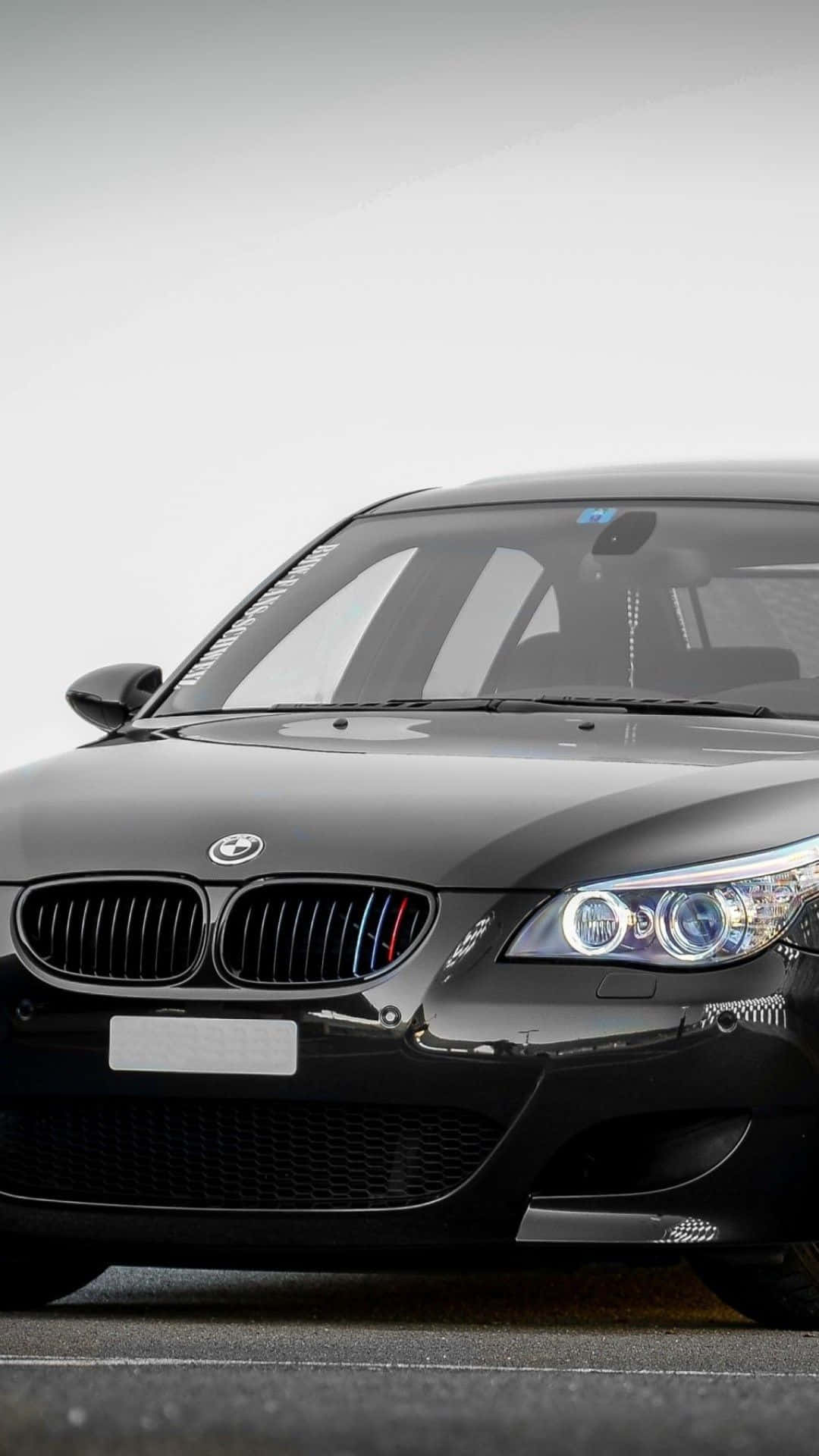 黑色BMW M5跑車，帶有發光的頭燈和M條紋。