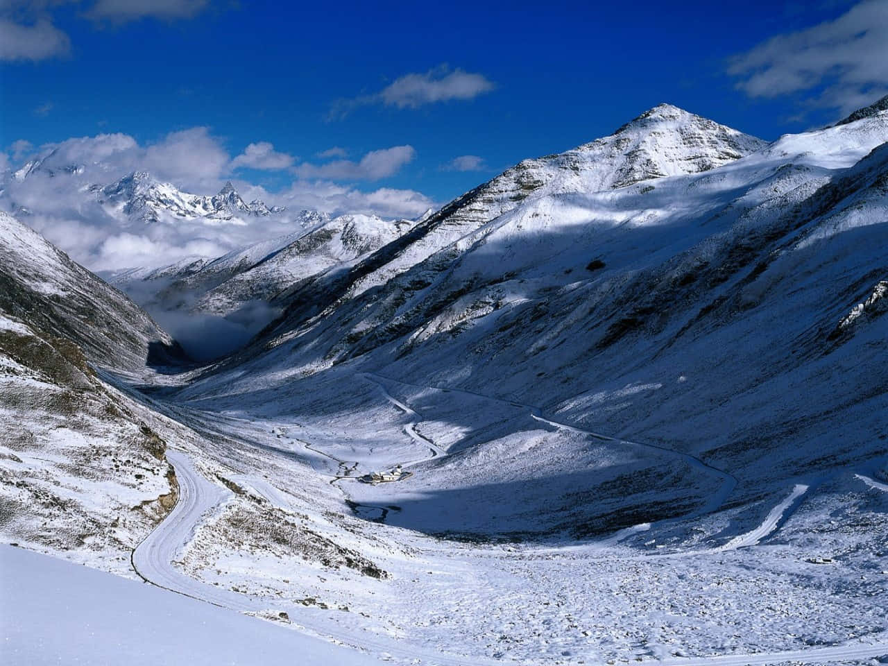 積雪的山口，蜿蜒的道路，藍天白雲