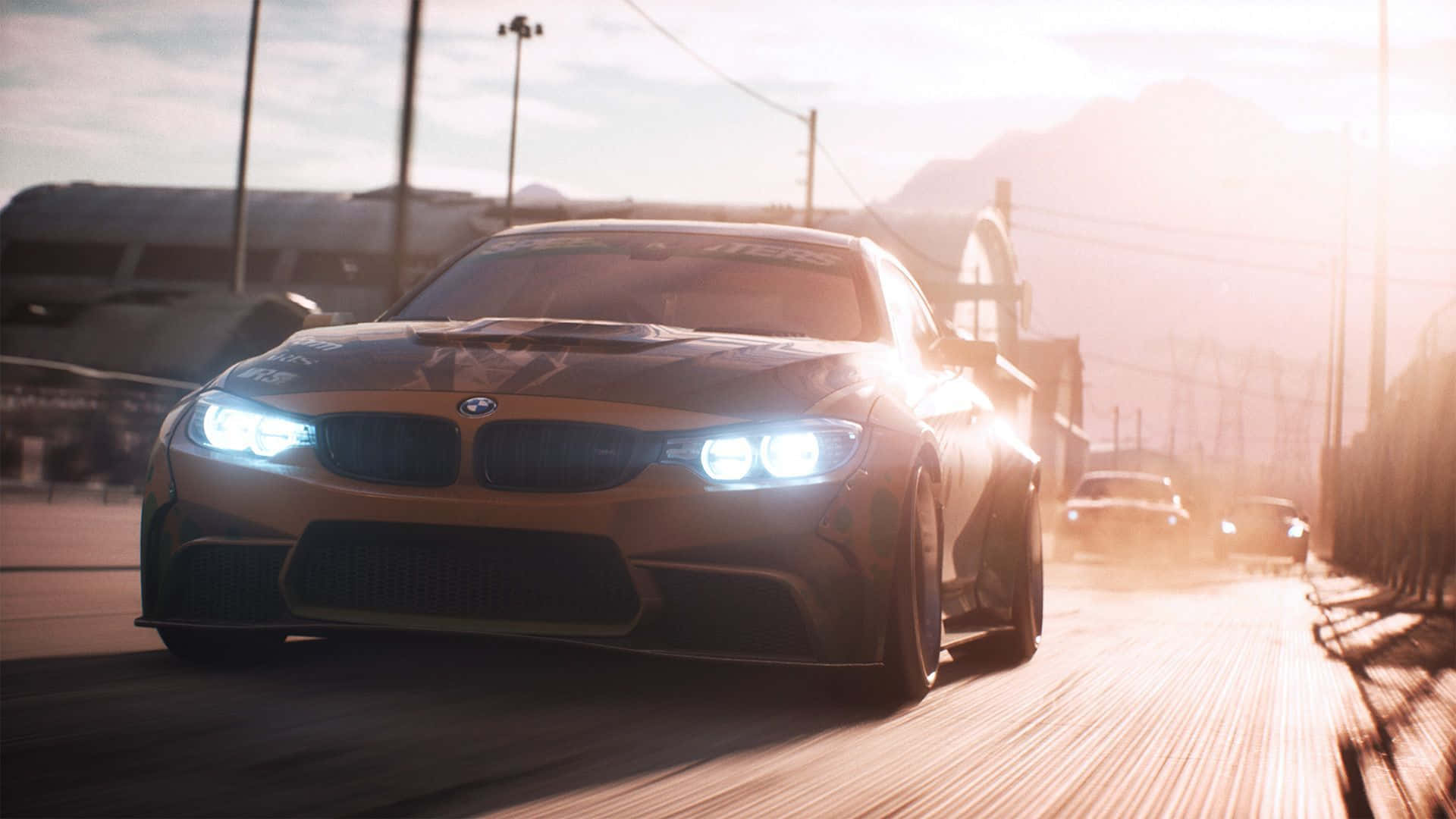 體驗即將登場的《Need for Speed Payback》驚心動魄的遊戲玩法！ 壁紙 — 一輛金色寶馬賽車在日落時分沿著塵土飛揚的賽道疾馳，車頭燈閃閃發光，背景是遠山。