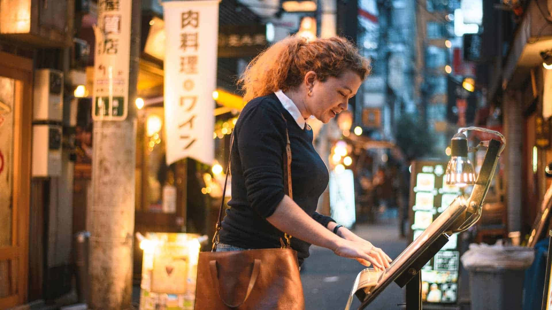 女性在霓虹燈照亮的東京小巷中彈奏街頭鋼琴