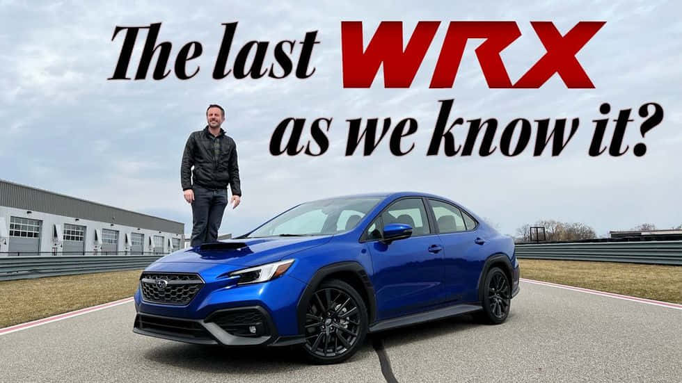 男子站在賽道上藍色 Subaru WRX 的引擎蓋上。