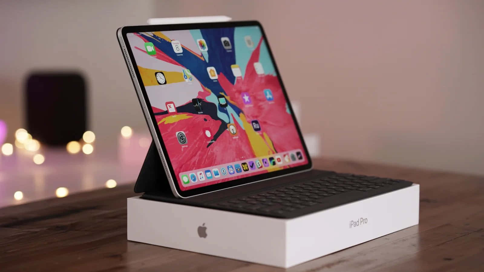 iPad Pro連鍵盤保護套放在木桌上的包裝盒上，帶有柔和背景光。