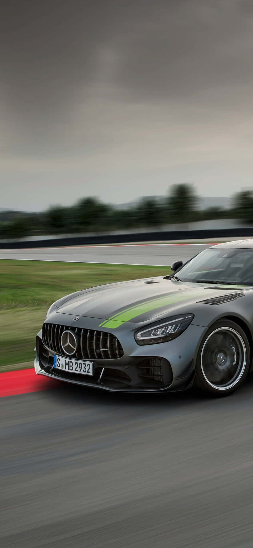 銀色 Mercedes-AMG GT 賽車在潮濕賽道上飛馳，帶有動態模糊效果。