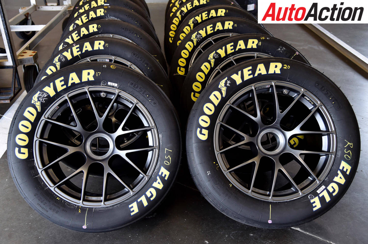車庫中帶有黑色輪圈和黃色字樣的Goodyear Eagle賽車輪胎。