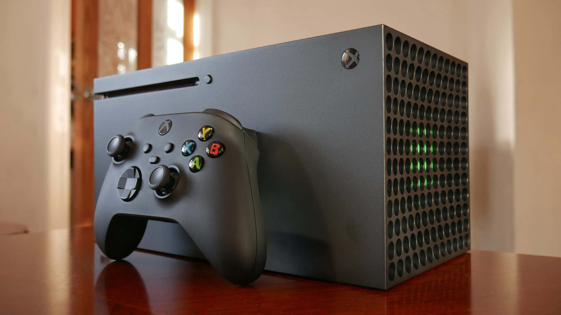 黑色 Xbox Series X 主機和控制器在木桌上。