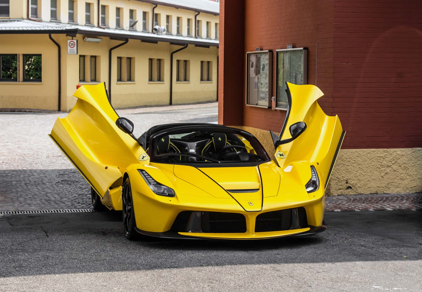 黃色法拉利 LaFerrari 打開鷗翼車門停在鵝卵石街道上。