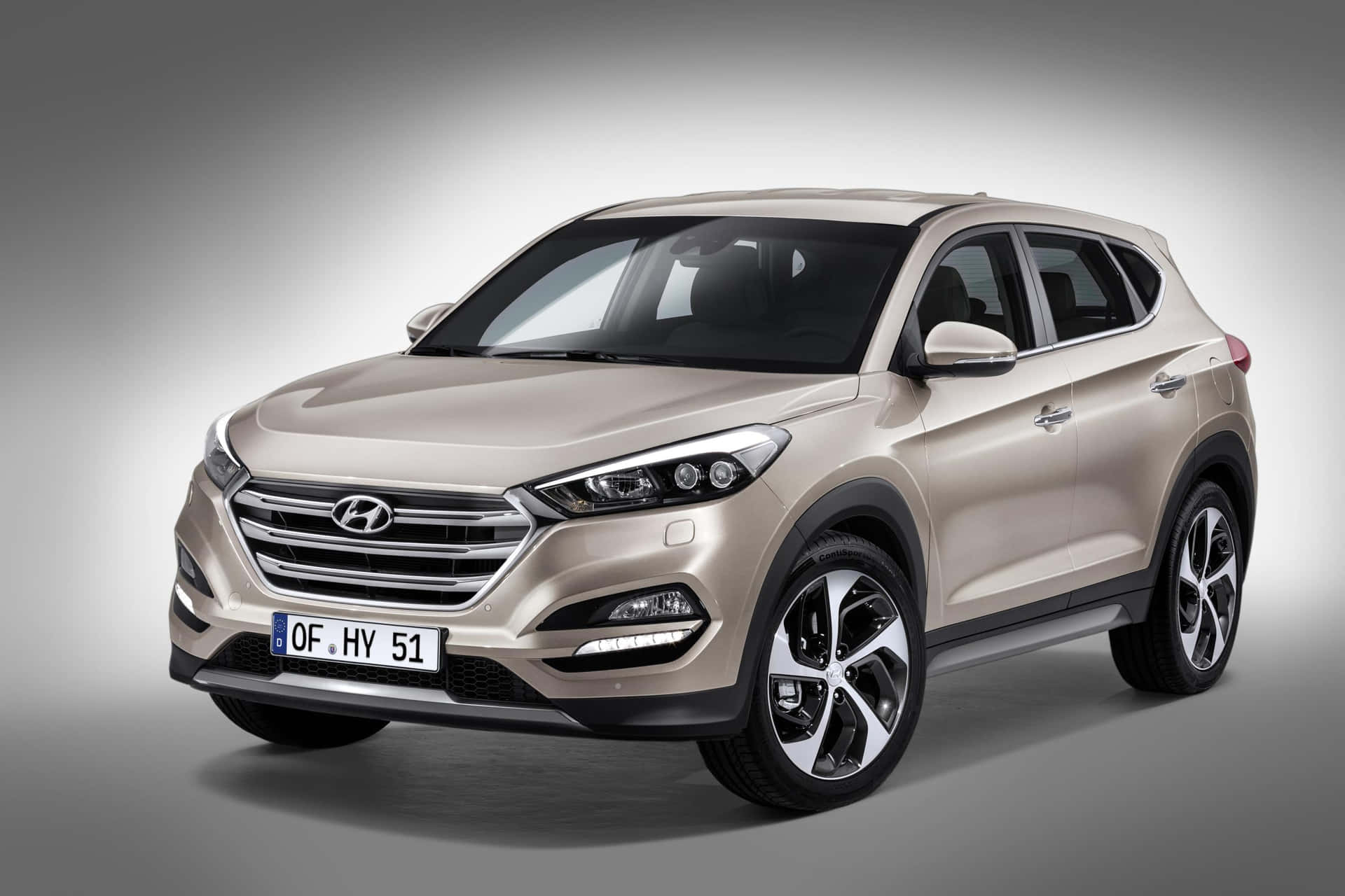 米色現代 Tucson SUV 在工作室燈光下配合金輪圈