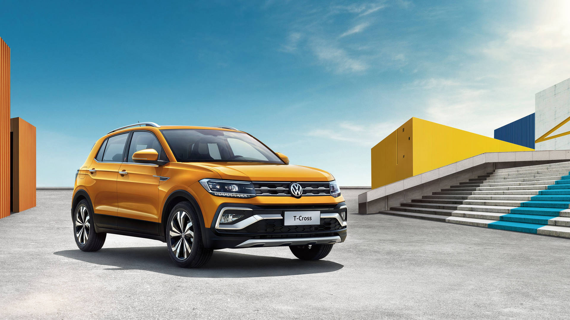 陽光明媚的日子裡，橙色福士 T-Cross SUV 停泊在色彩繽紛的現代建築附近。