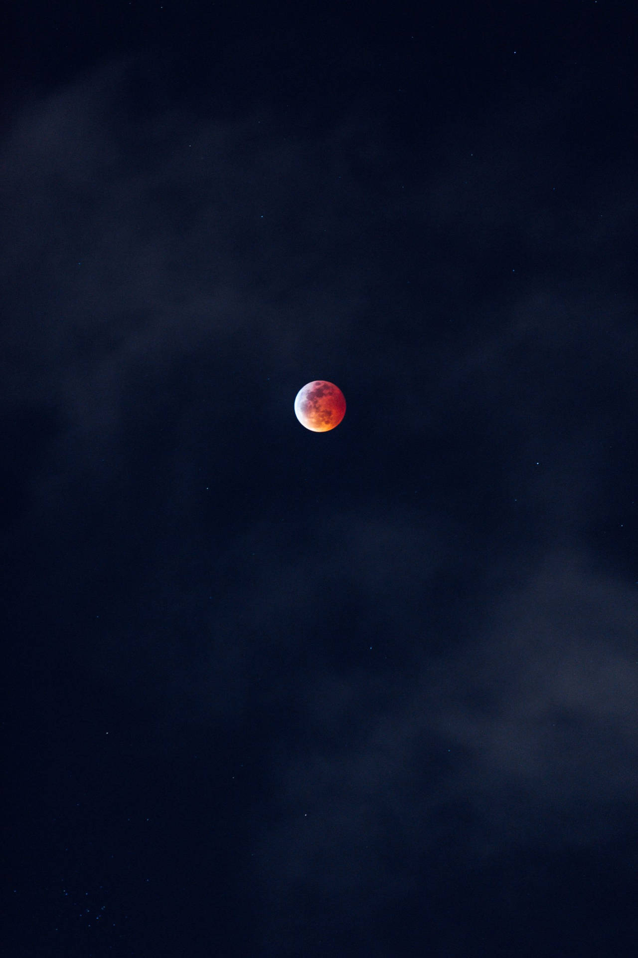 血月在黑暗多雲的夜空中與星星一同發光