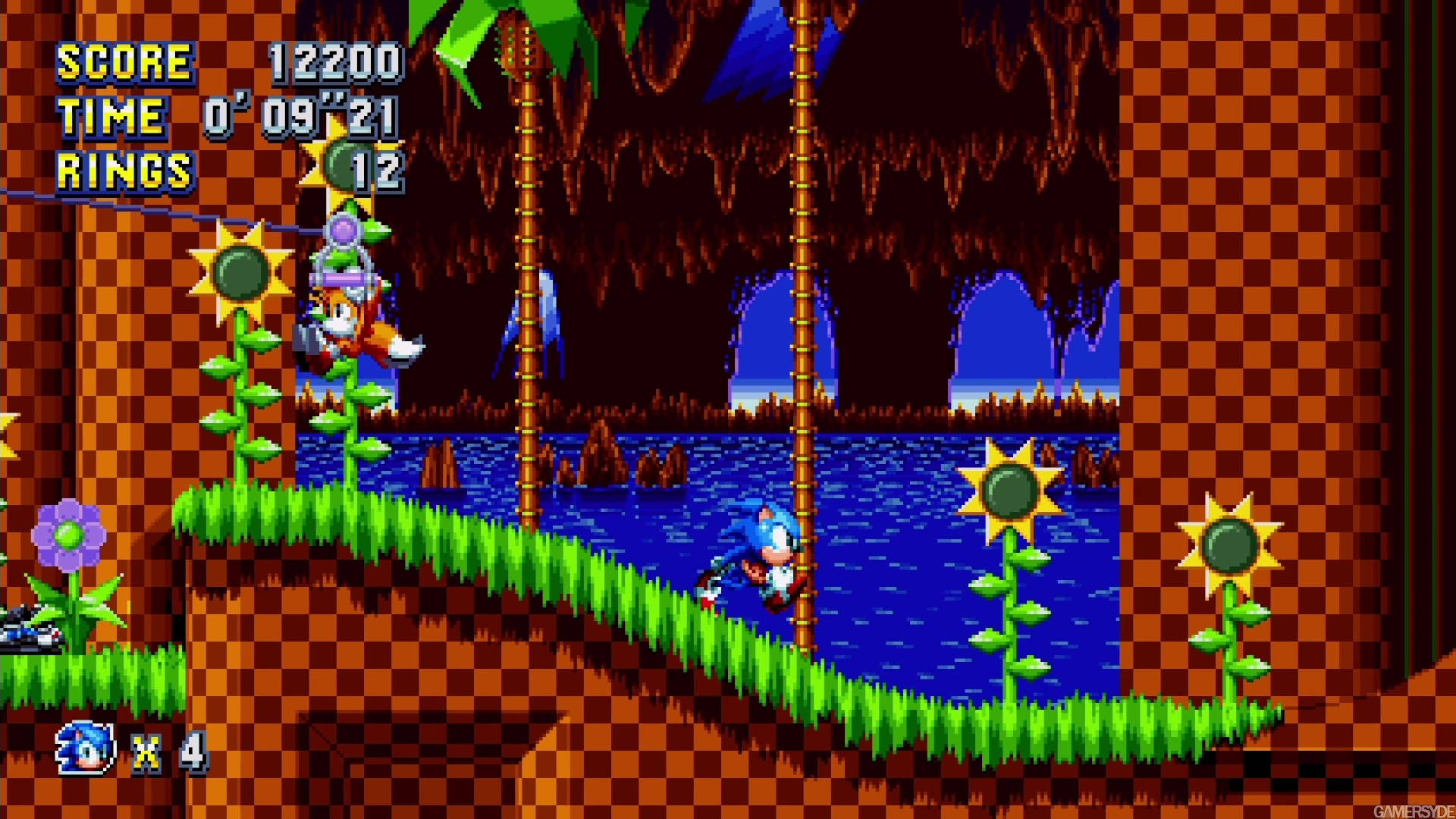 Sonic the Hedgehog 喺一個有向日葵同水嘅像素化叢林遊戲關卡中奔跑。