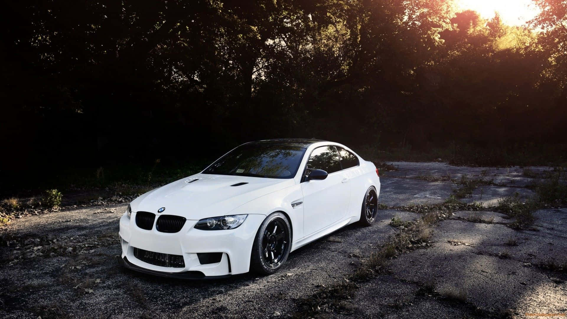白色BMW M3跑車在日落時停泊在碎石路上。