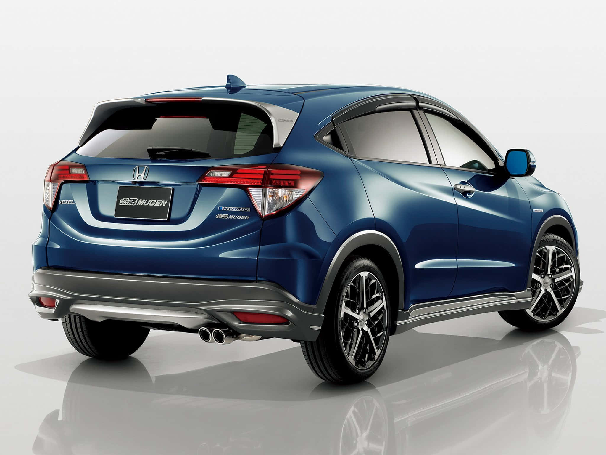 體驗駕駛Honda的刺激感 壁紙 — 一輛時尚的藍色本田 HR-V Mugen 性能 SUV，從後方四分之三角度在反光工作室地板上展示。