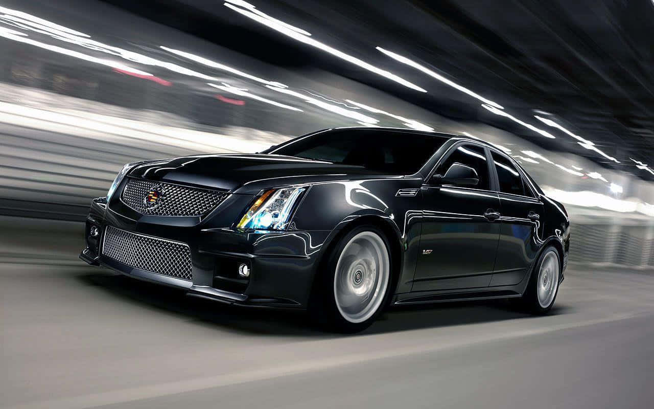 黑色Cadillac CTS-V在照明隧道中疾馳，帶有動態模糊效果。
