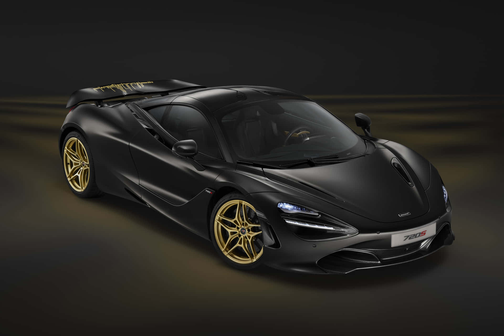 啞光黑色McLaren 720S，金色輪圈和發光車頭燈，在深色工作室中。