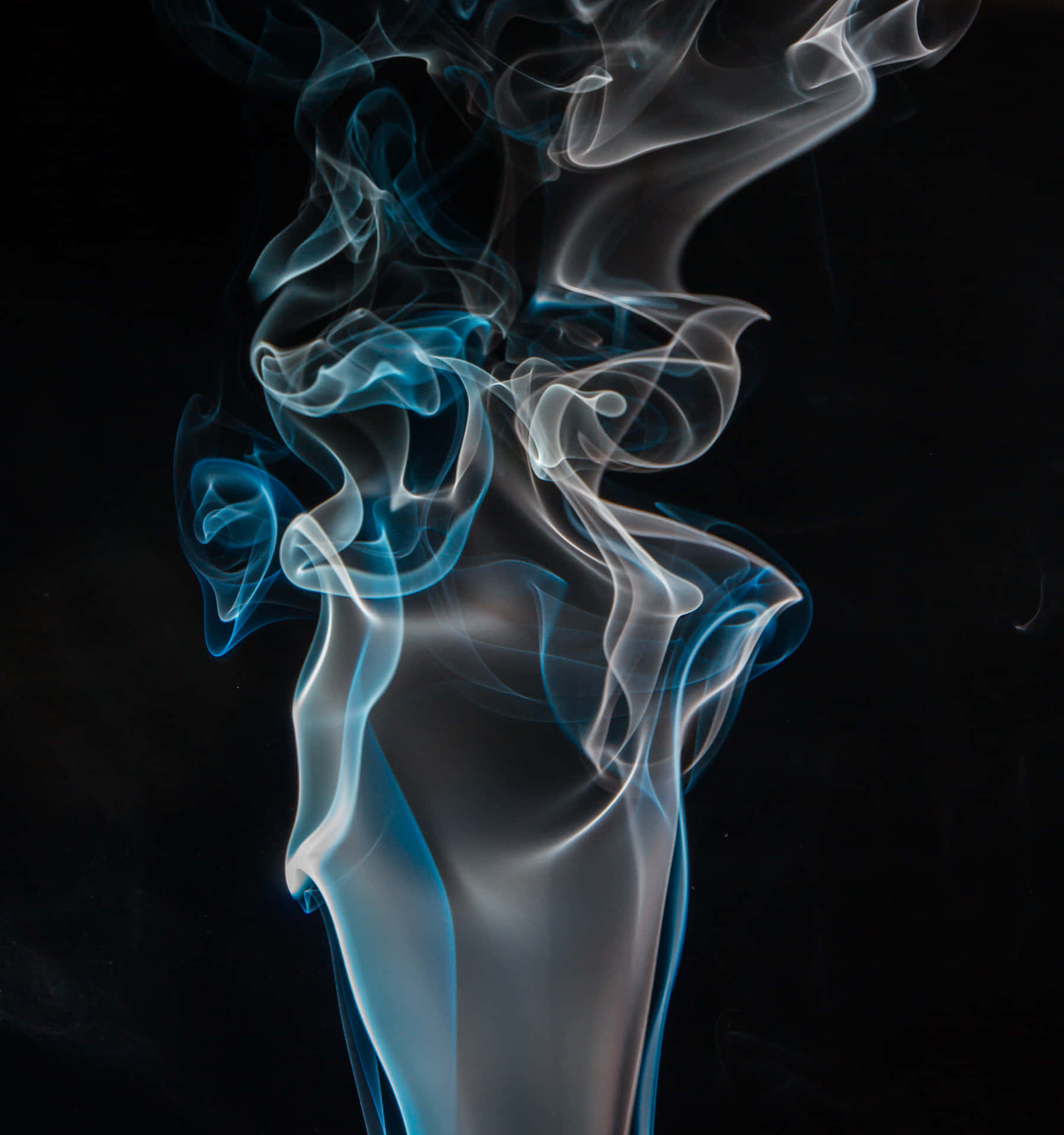 藍色和白色煙霧在黑色背景上以優雅的漩渦升起。