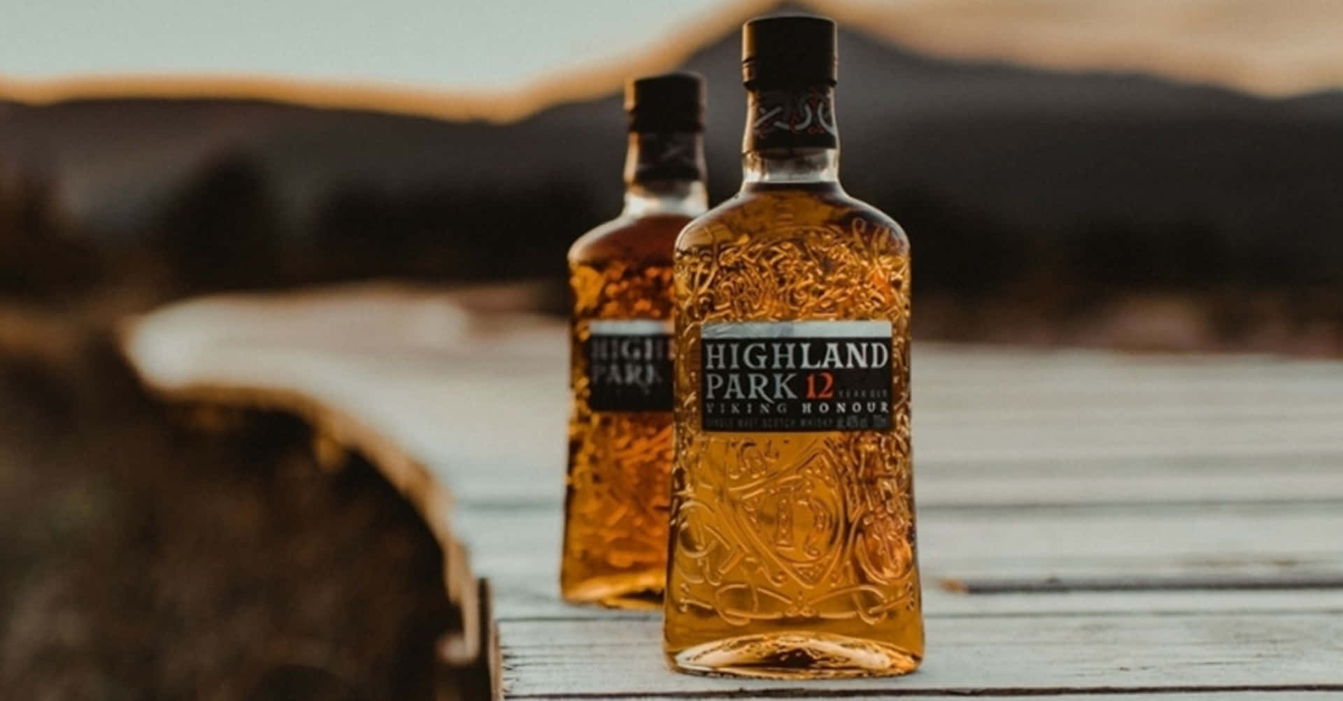 日落時分，木碼頭上的兩瓶 Highland Park 威士忌。