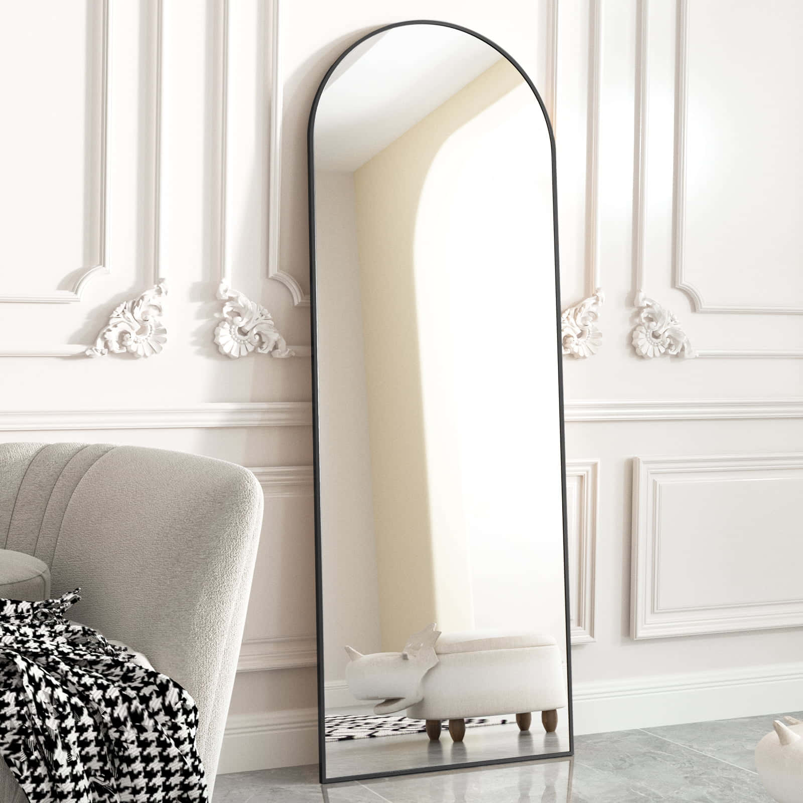 Classically beautiful bathroom with a golden-framed mirror 壁紙 — 高大的拱形鏡子帶有黑色幼框，靠在裝飾性白色牆壁上，旁邊是灰色扶手椅，上面鋪著千鳥格毯子。