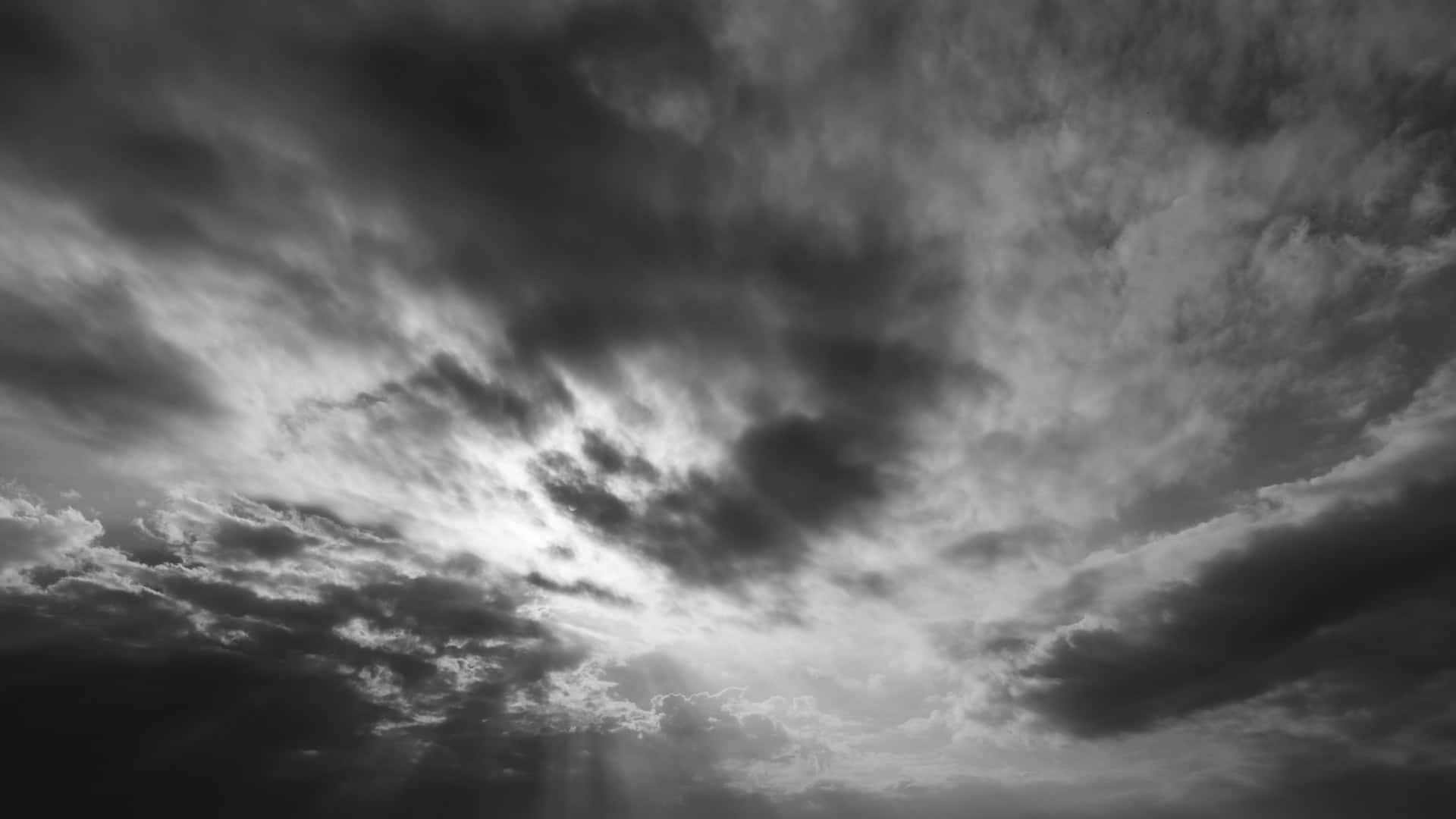 Dark Heaven 桌布 壁紙 — 高對比天空下，戲劇性的單色雲層中透出陽光。