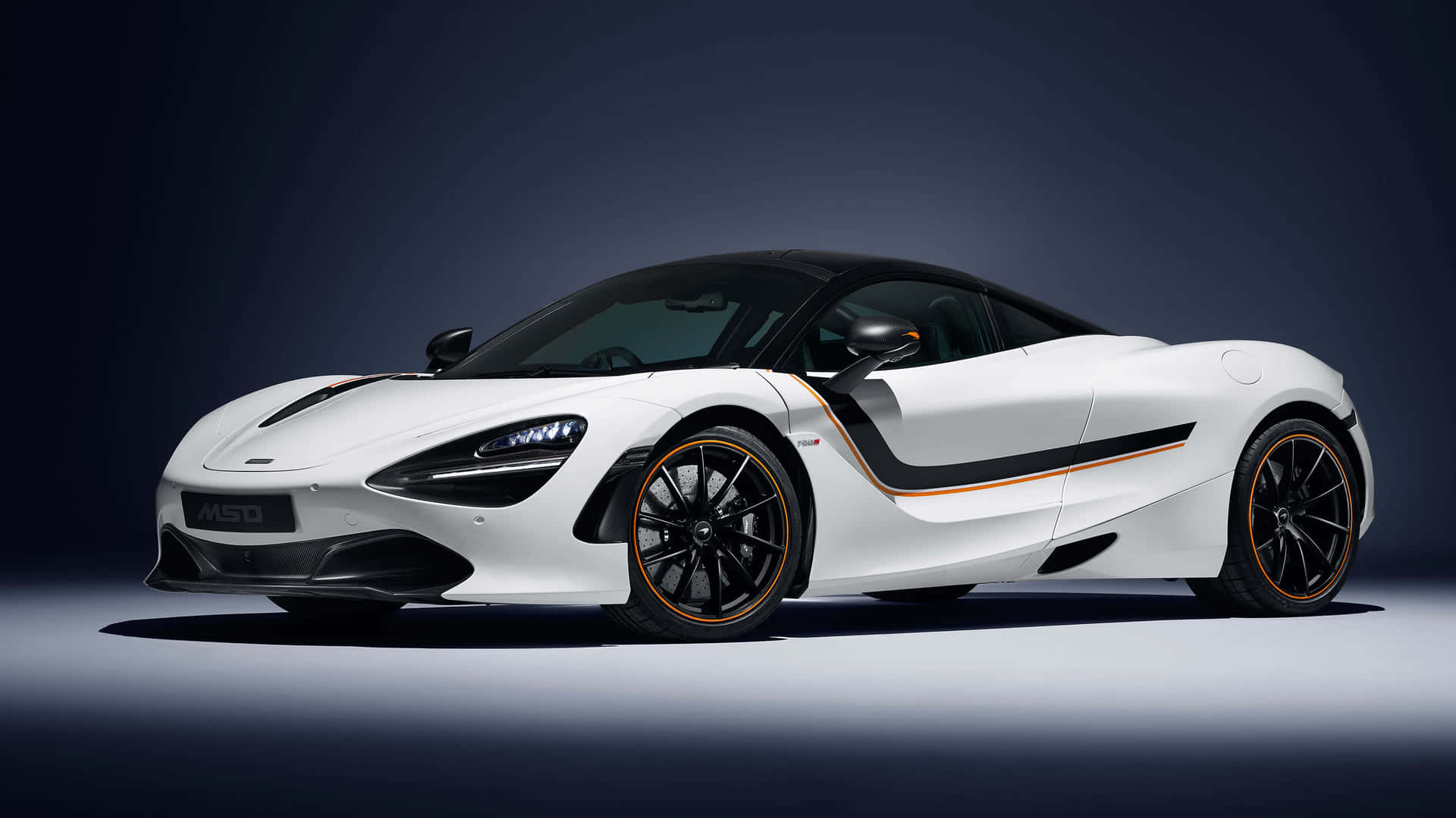 白色McLaren 720S跑車，帶有黑色和橙色細節，在工作室燈光下。