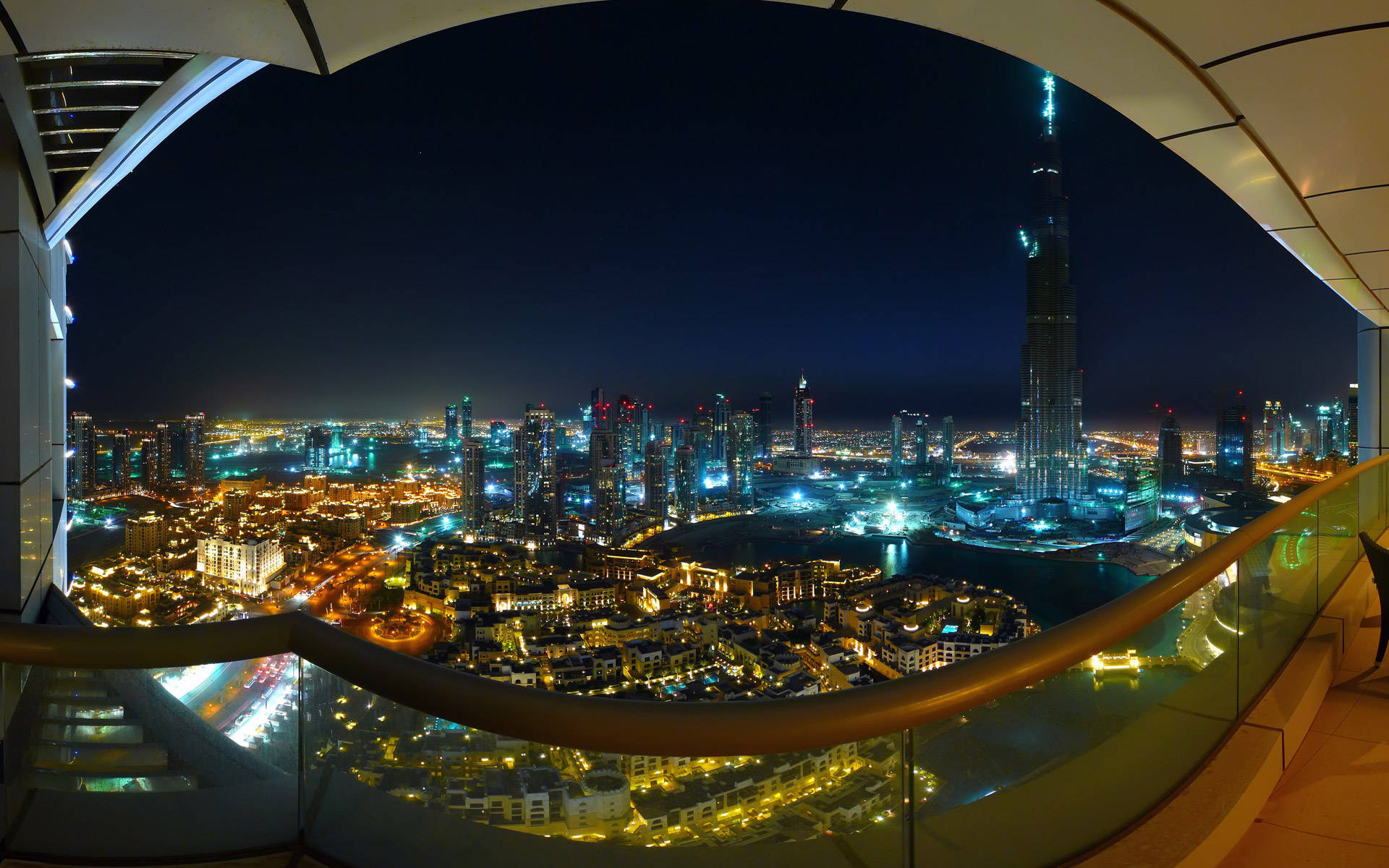 從弧形玻璃陽台觀賞杜拜天際線的夜景，哈利法塔燈火通明。