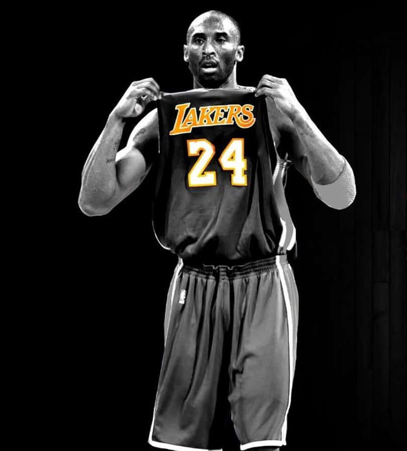 Kobe 桌布 壁紙 — 高比拜仁在戲劇性的工作室肖像中，在純黑色背景前舉起他標誌性的湖人隊24號球衣。