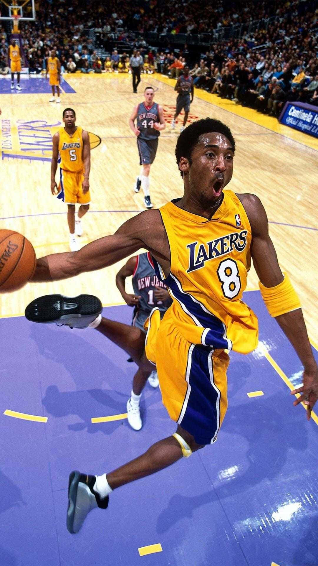 Kobe 桌布 壁紙 — 高比拜仁身穿黃色湖人球衣，在明亮的場館燈光下，於激烈的NBA比賽中跳起持球。