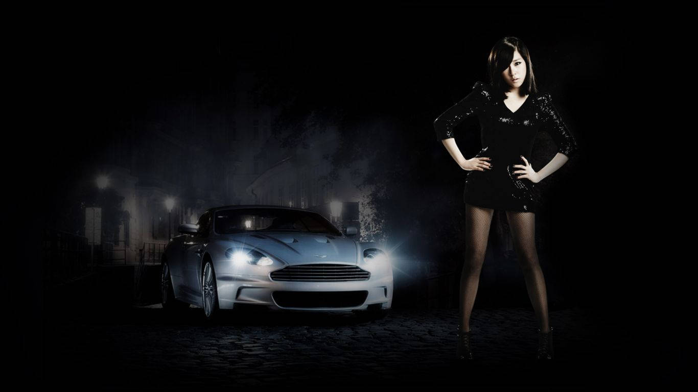 高清少女時代Tiffany 壁紙 — 一位身穿黑色連衣裙的女性自信地站在一輛閃亮的銀色跑車旁，在昏暗的路燈下，身處黑暗的城市小巷中。