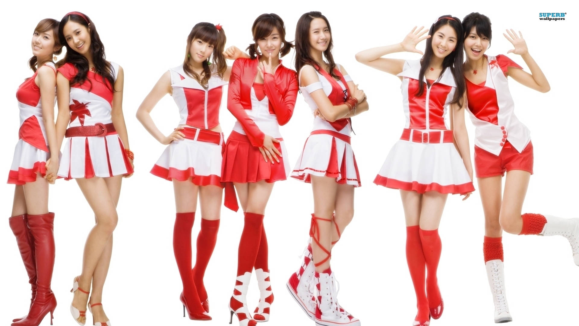 高清少女時代任天堂大使形象 壁紙 — 七位微笑的女性穿著相配的紅白啦啦隊服裝，在純白色背景前俏皮地擺姿勢。
