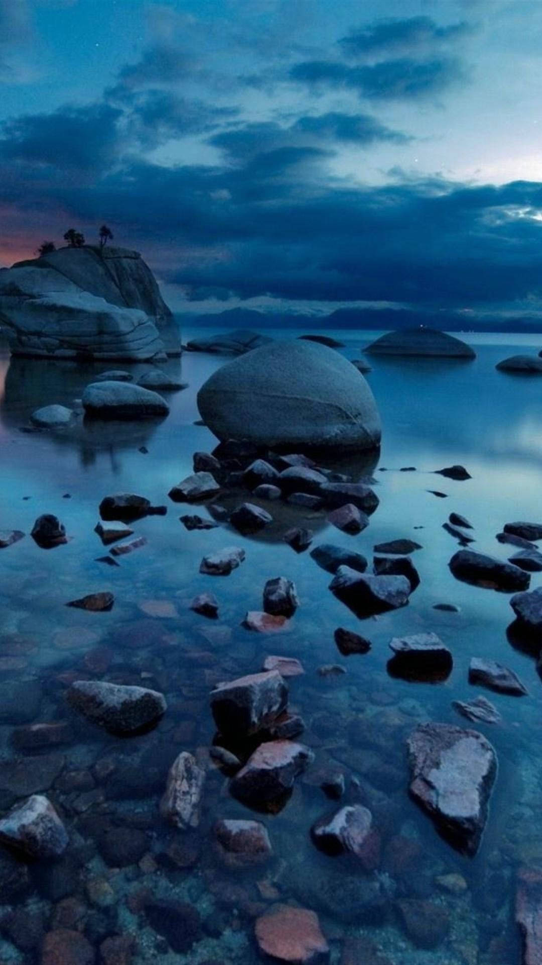 黃昏湖泊，岩石和平靜的水面倒映天空