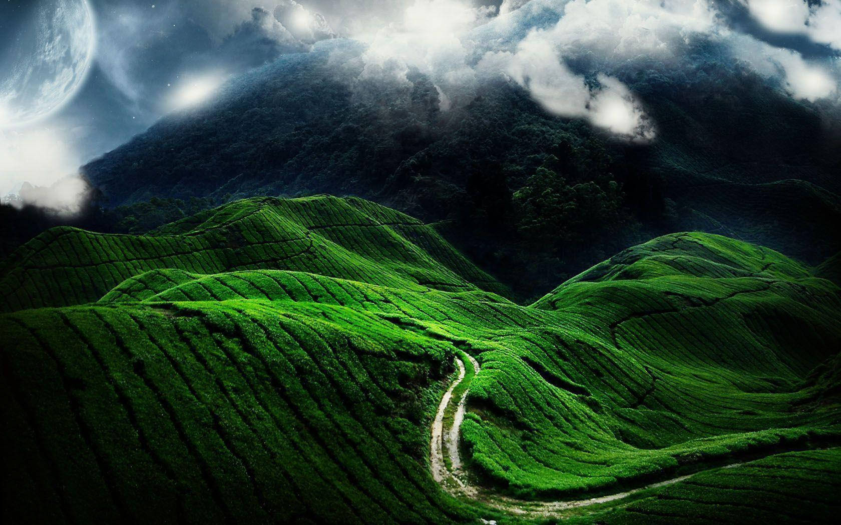 高清自然風景：綠色山丘 壁紙 — 一條蜿蜒的泥土小徑穿過充滿活力的綠色梯田山丘，在戲劇性的多雲天空下，有一輪發光的月亮。
