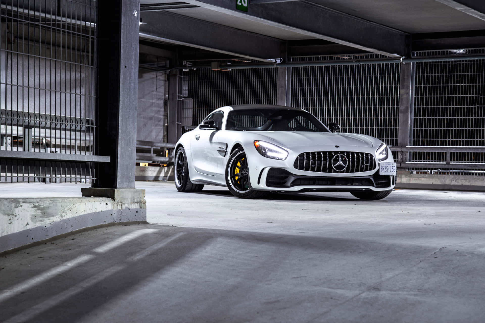 白色Mercedes-AMG GT跑車停泊在工業地下停車場。