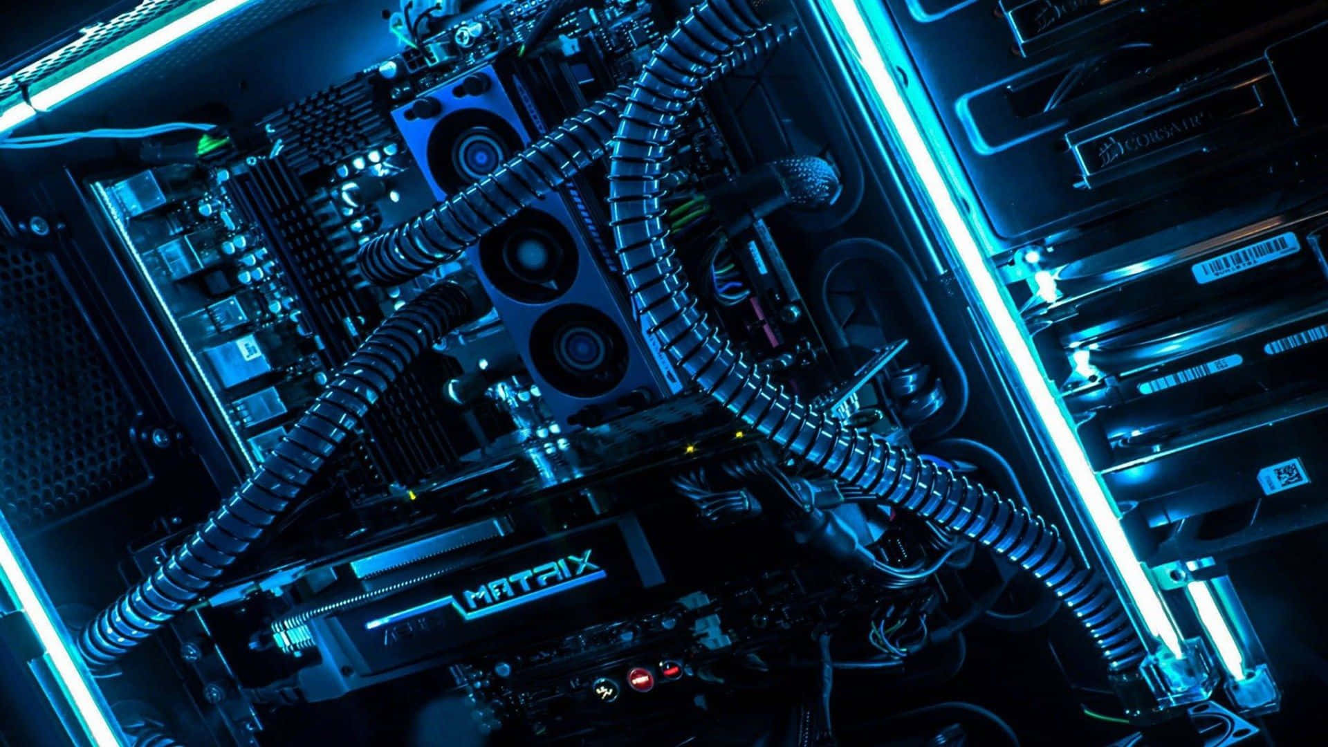Cool Gaming 桌布 壁紙 — 高科技電腦機箱內部，沐浴在充滿活力的藍色LED燈光中，展示複雜的冷卻管道和電路。