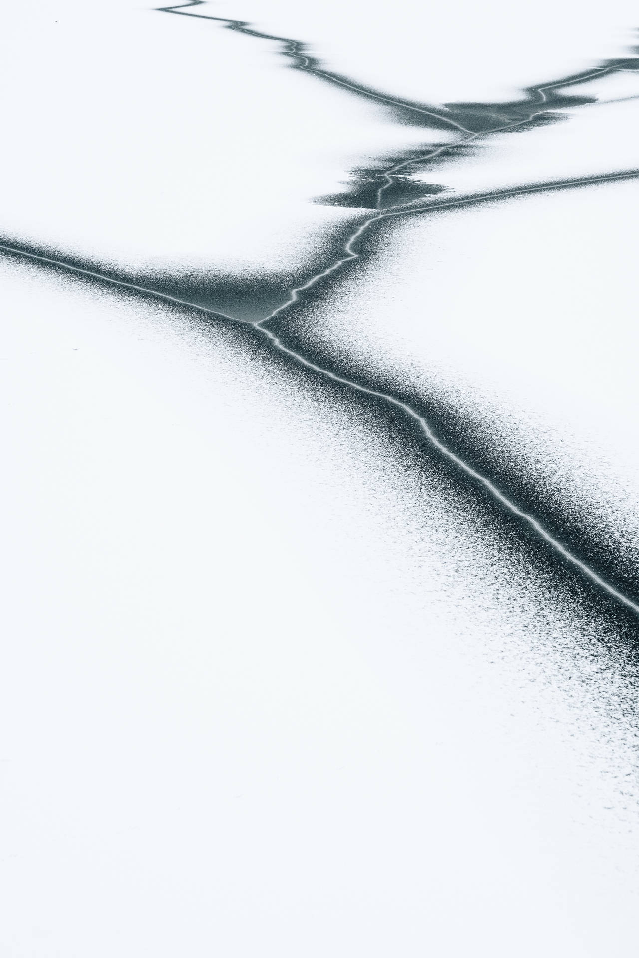 裂開的雪面，黑色線條形成抽象幾何圖案。