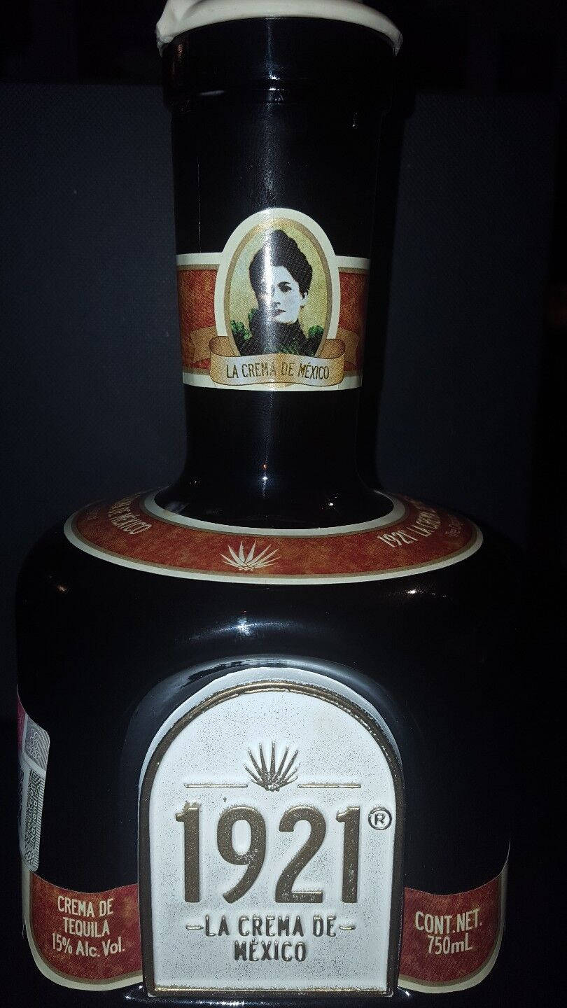 帶有復古標籤和肖像的深色龍舌蘭酒瓶。