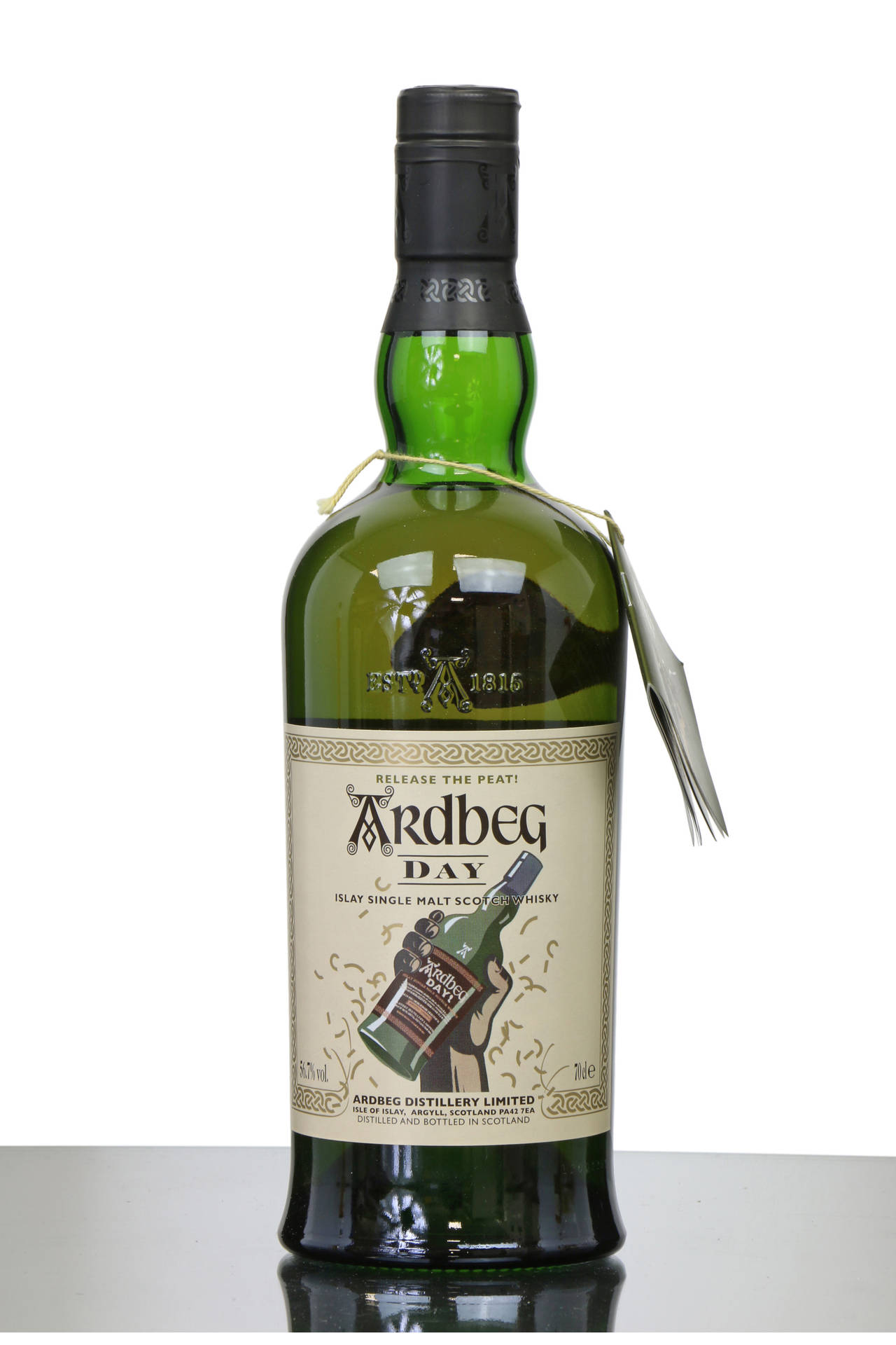 反射表面上的綠色Ardbeg Day威士忌瓶，帶有標籤和吊牌。