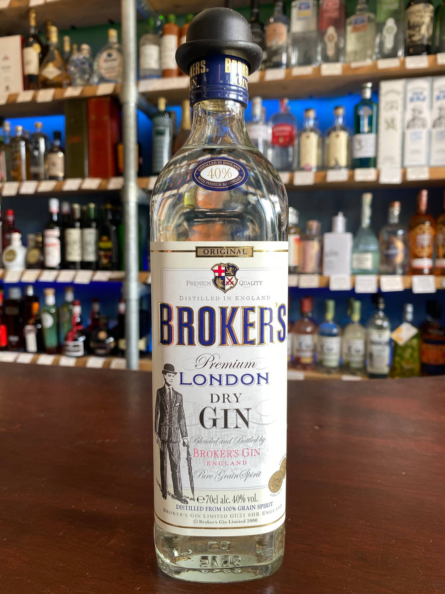 吧檯上的一瓶Broker's London Dry Gin，後面有酒架。
