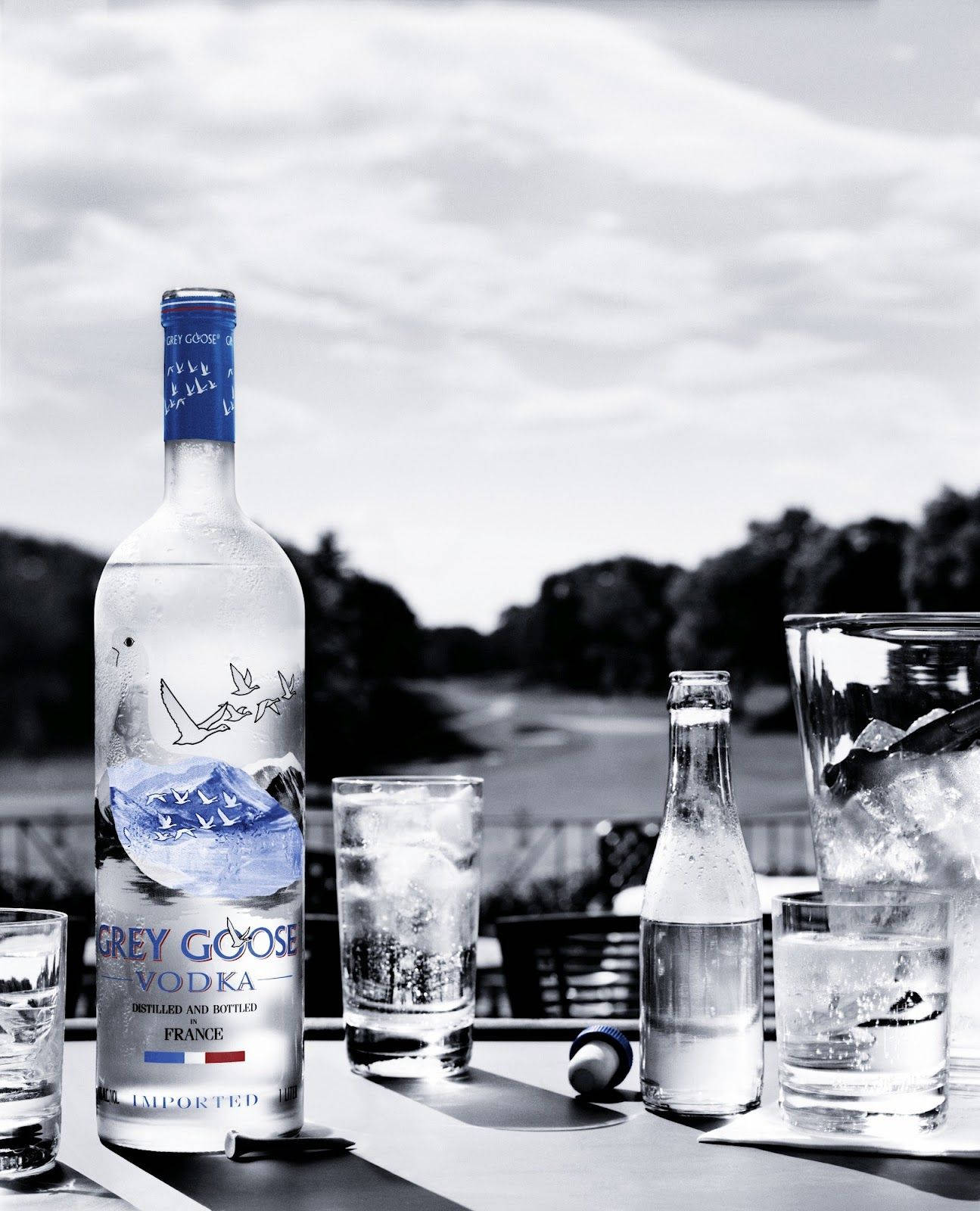 Grey Goose 伏特加酒瓶和加冰的酒杯放在戶外的桌子上。