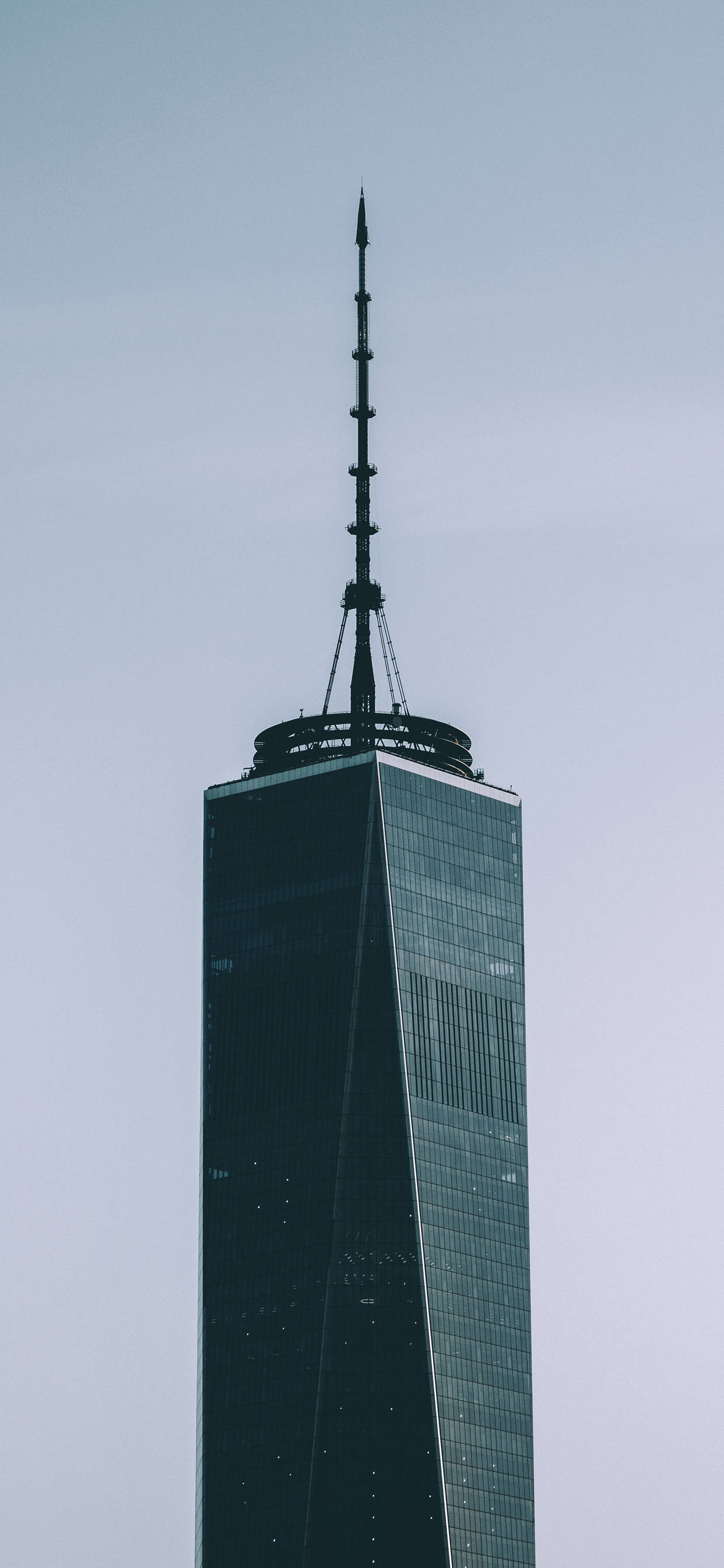 Skyscraper 桌布 壁紙 — 高聳的摩天大樓，玻璃幕牆和尖頂刺穿蒼白的天空，極簡主義城市拍攝。