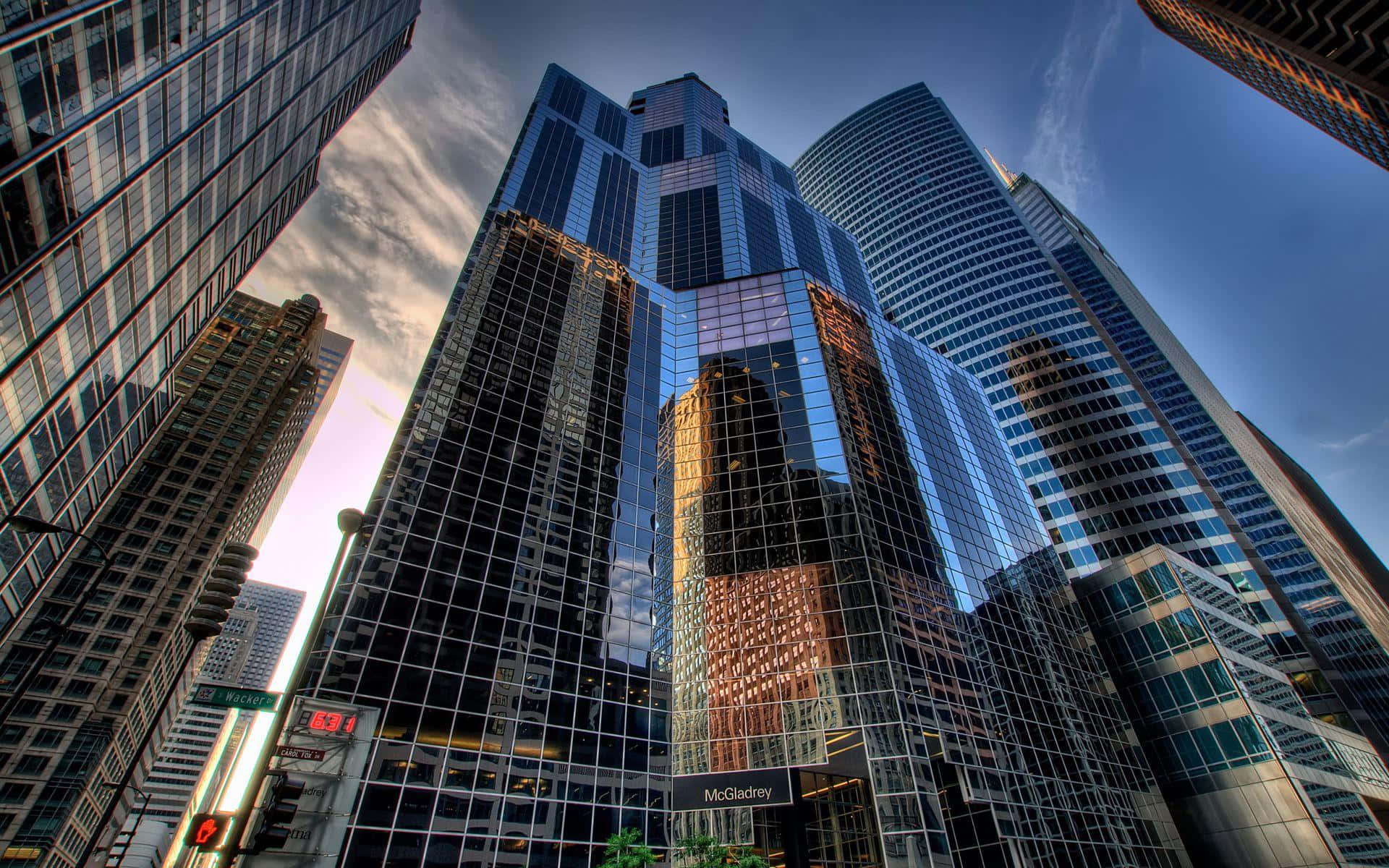 Buildings 桌布 壁紙 — 高聳的玻璃摩天大樓刺穿暮色天空，下方有戲劇性的倒影和溫暖的路燈。