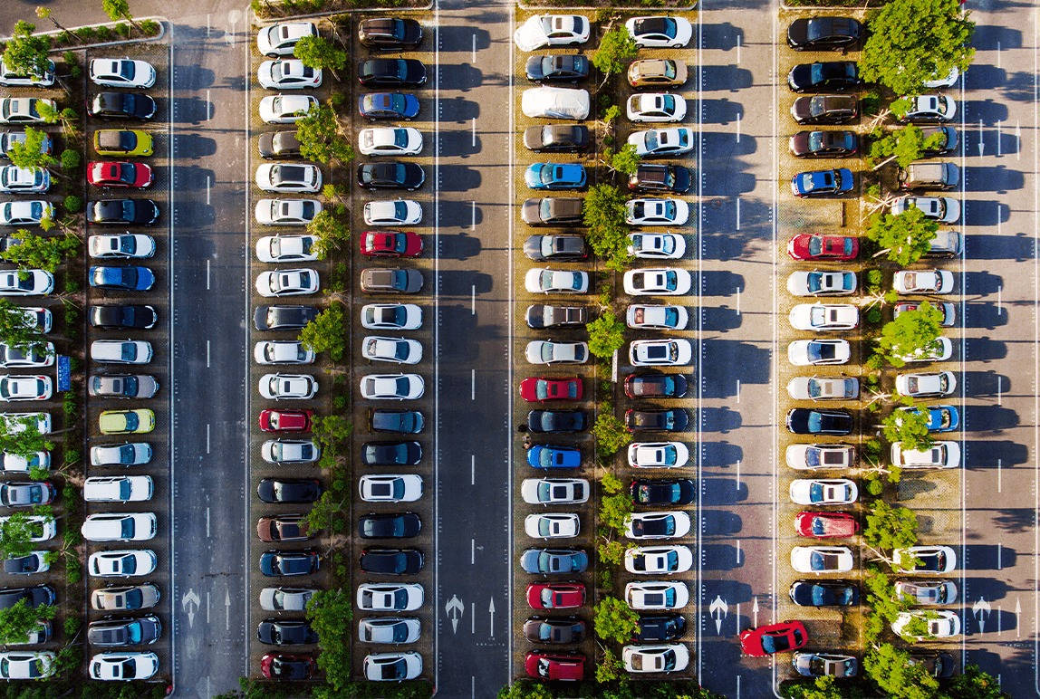 從正上方俯瞰停車場，可見一排排色彩繽紛的汽車和綠樹。