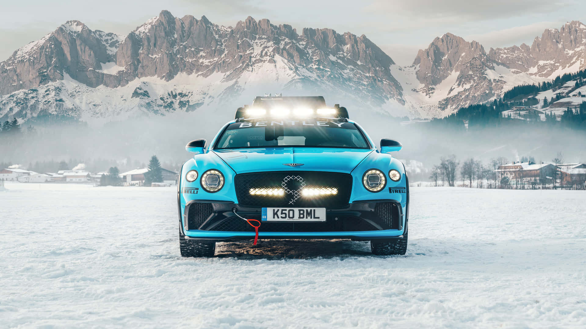 藍色賓利 Bentayga 雪地性能車停放在白雪覆蓋的高山景觀中。