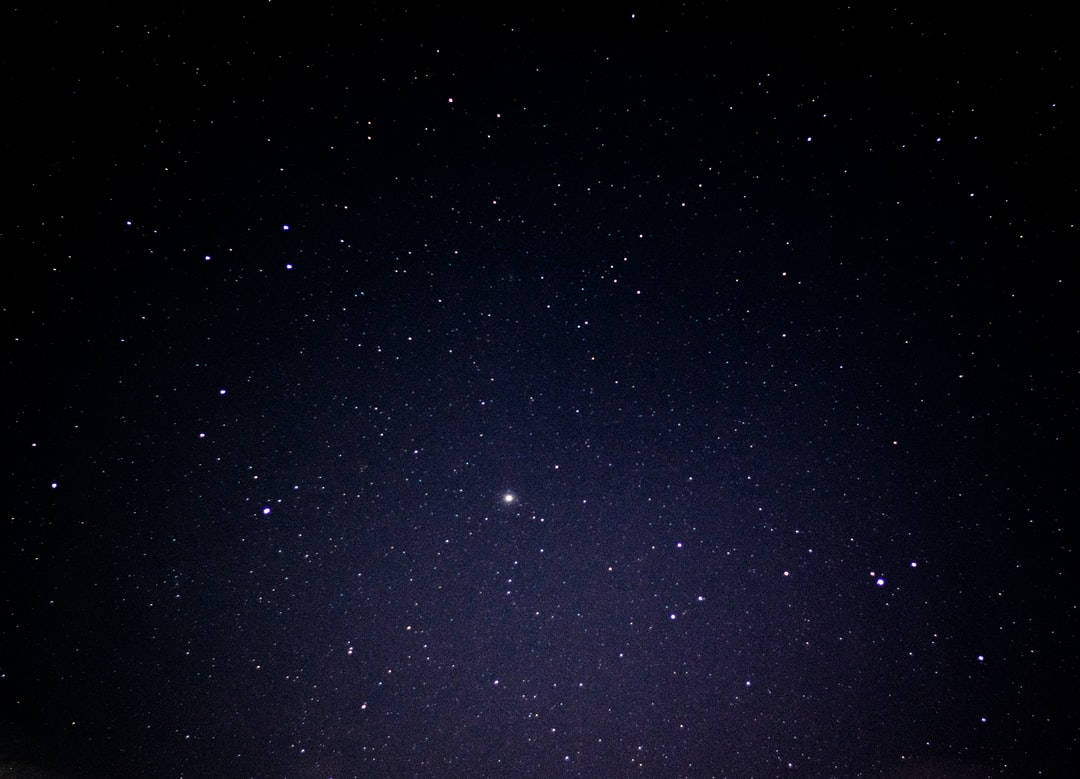 一個繁星點點的夜空，遠處有一個明亮的星體在發光。